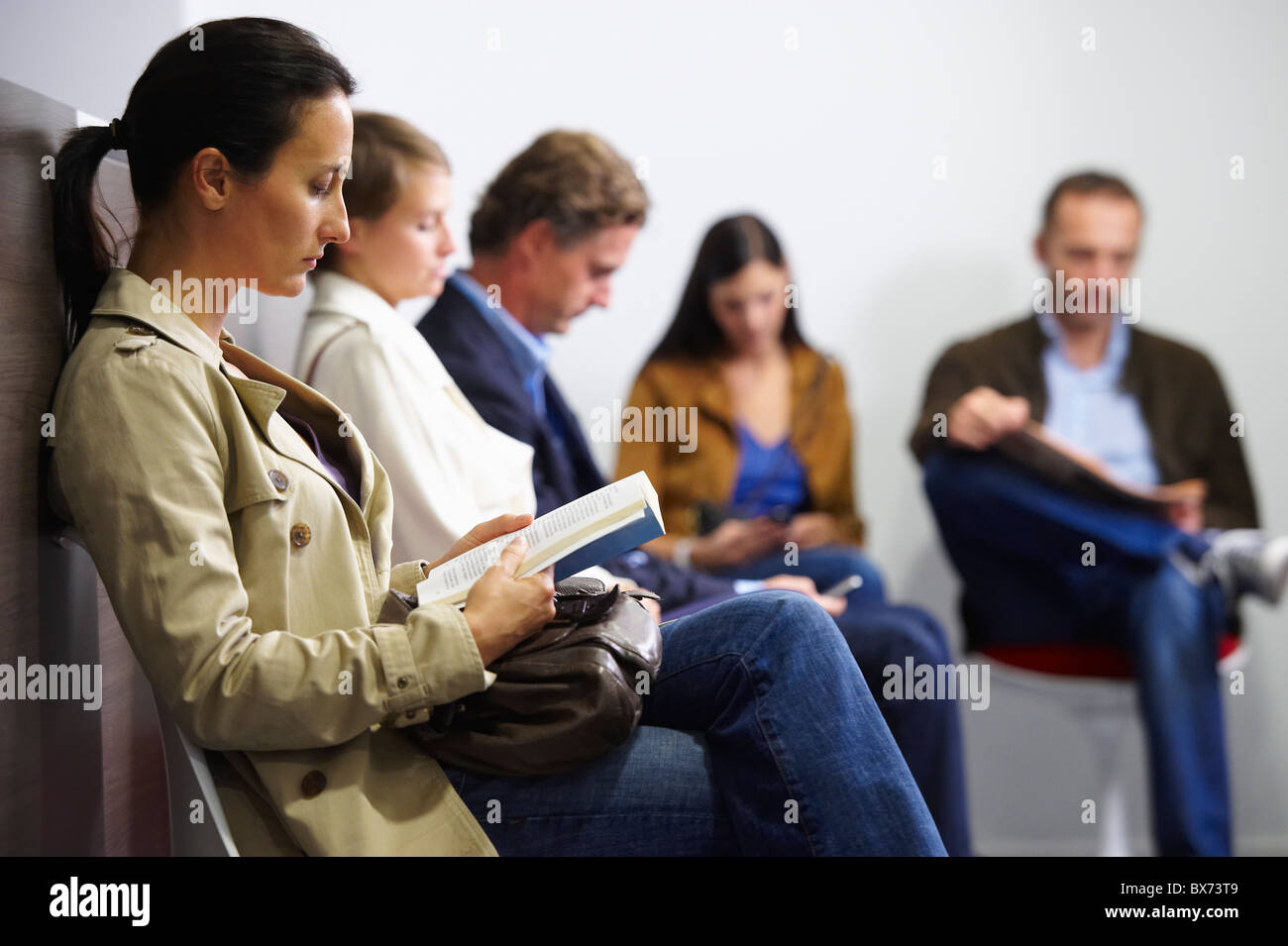 Les gens assis dans une salle d'attente Banque D'Images