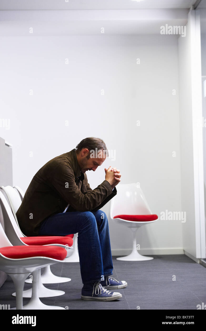 Homme assis dans sa salle d'attente du médecin Banque D'Images