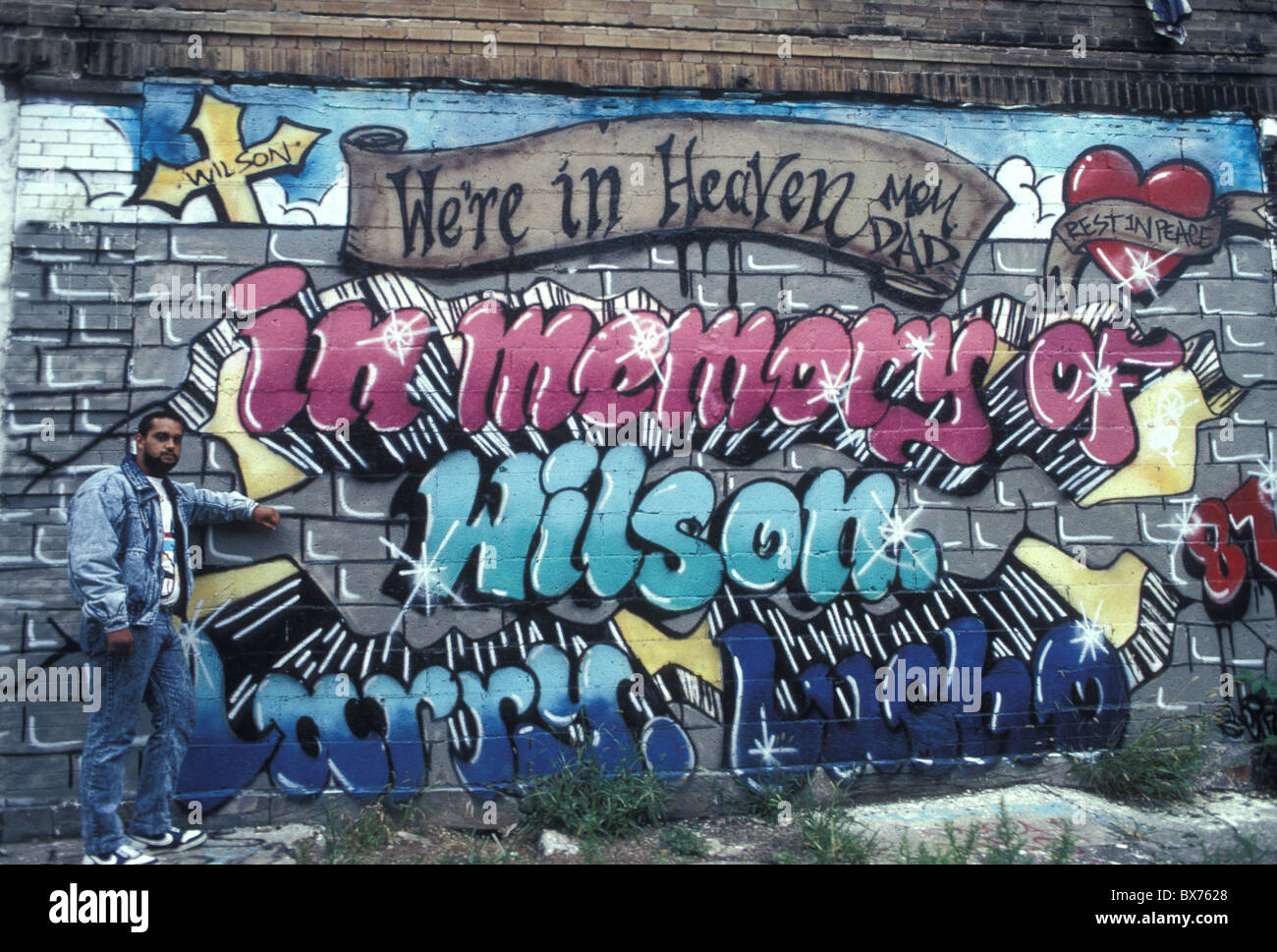 L'homme se tient à côté d'un mémorial pour un ami et membre de gang à Bushwick, Brooklyn, New York. Banque D'Images