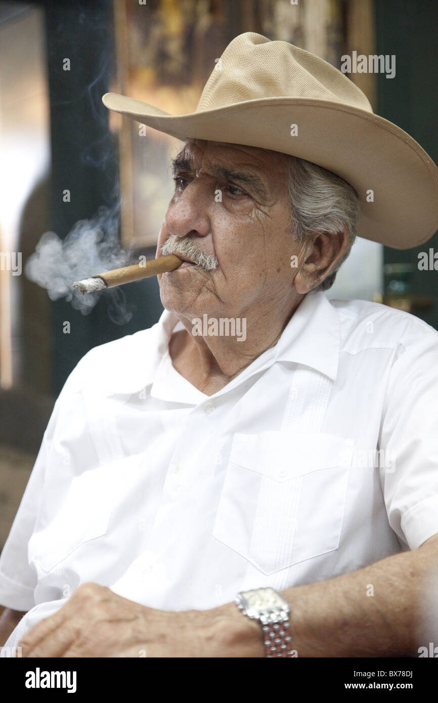 Fumer un cigare cubain emigre portant un chapeau de cow-boy dans la Calle Ocho, Miami, Floride, États-Unis d'Amérique, Amérique du Nord Banque D'Images