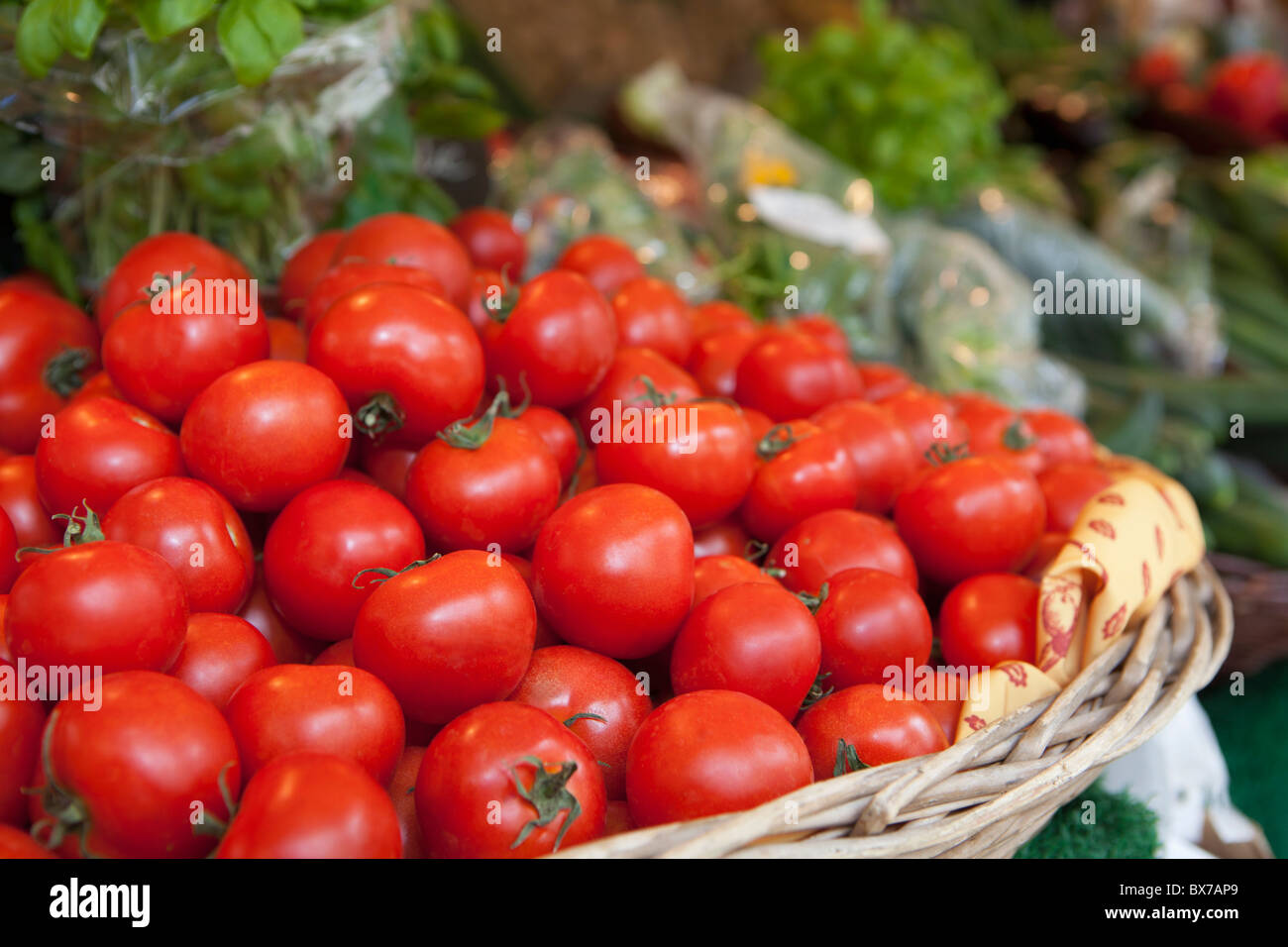 Un panier plein de tomates sur un marché Banque D'Images