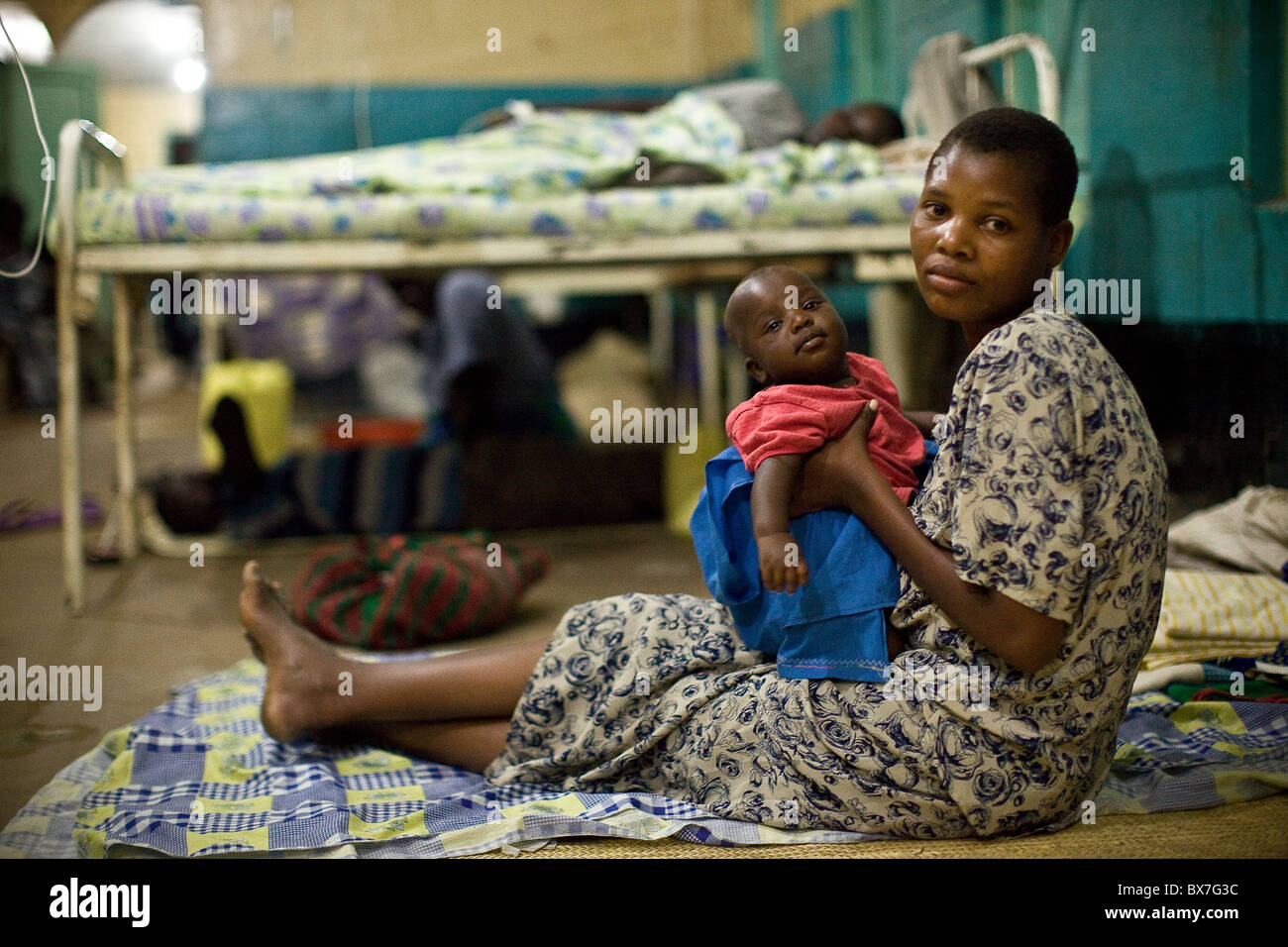 Une mère dort sur le sol d'un hôpital surpeuplé dans Amuria, sous-région de Teso, Ouganda, Afrique de l'Est. Banque D'Images