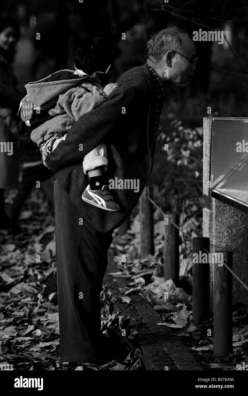 Vieil homme portant un enfant sur son dos dans le parc Ueno, Tokyo, Japon Banque D'Images
