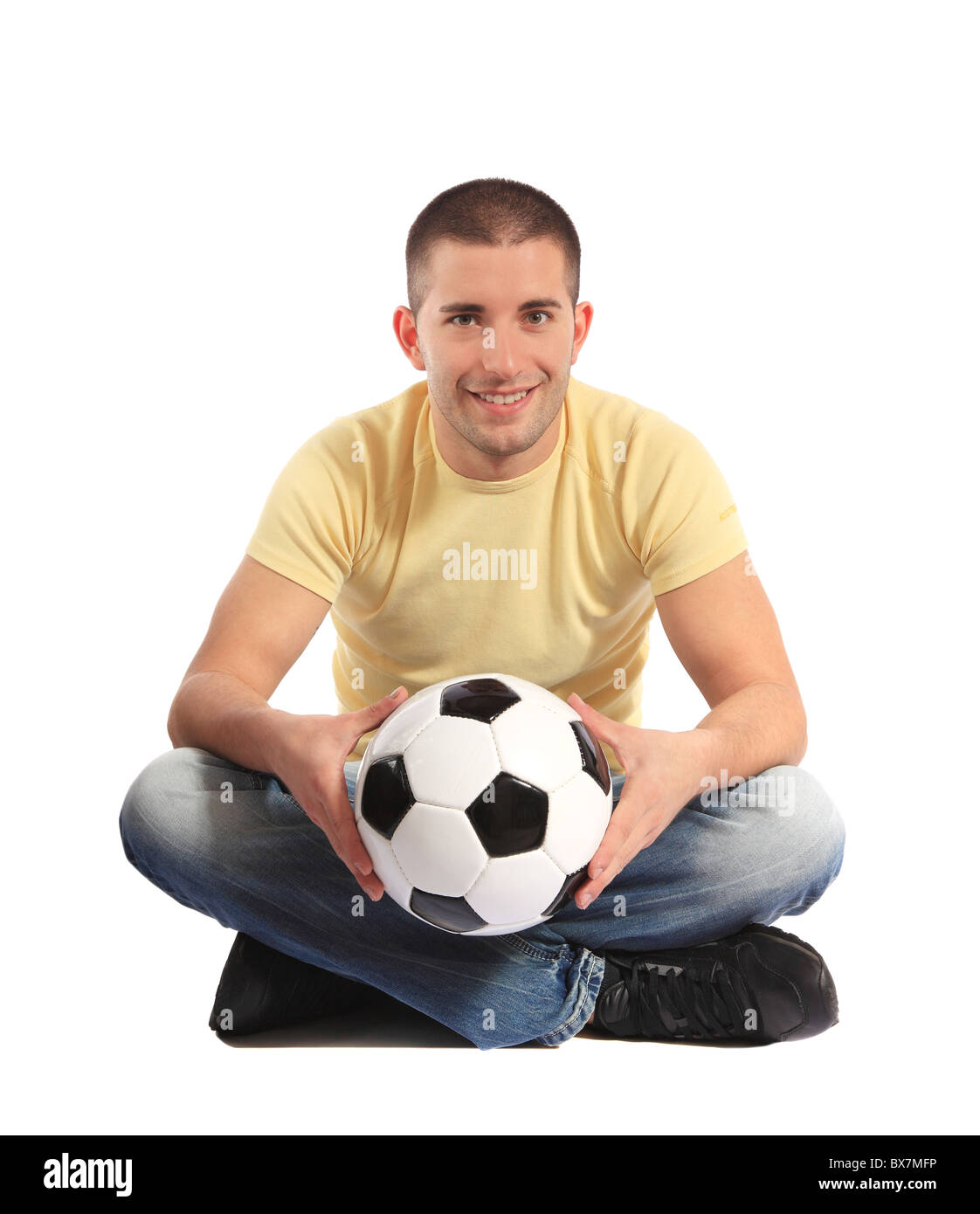 Beau Jeune homme tenant un ballon de soccer. Le tout sur fond blanc. Banque D'Images