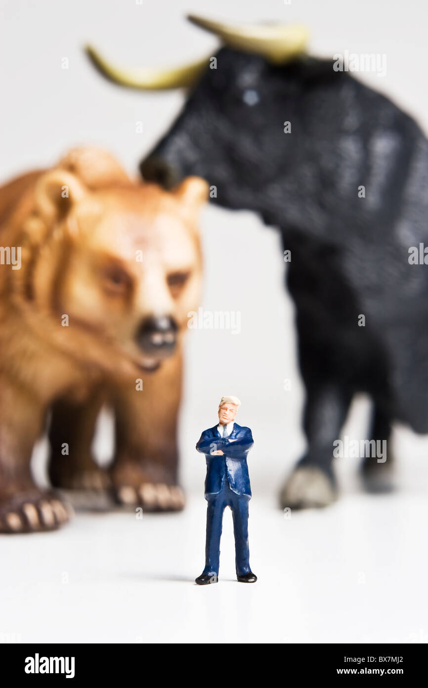 Figurines d'affaires placés avec Bull et bear de figurines. Banque D'Images