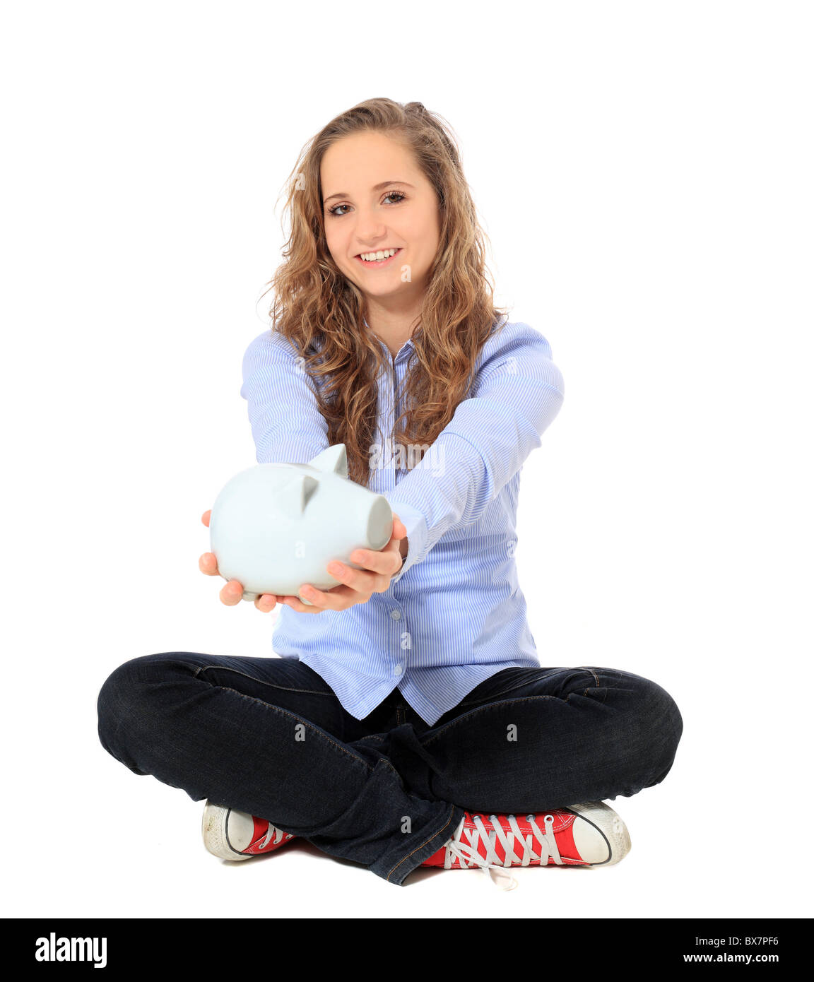 Young Girl holding piggy bank. Le tout sur fond blanc. Banque D'Images