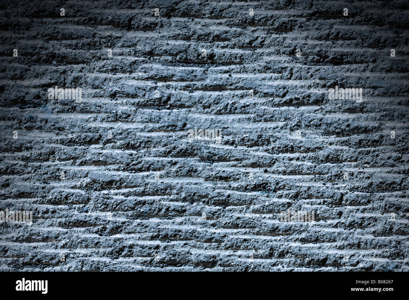 Asphalte rainuré ou rock surface texture allumé du dessus avec lumière bleue Banque D'Images