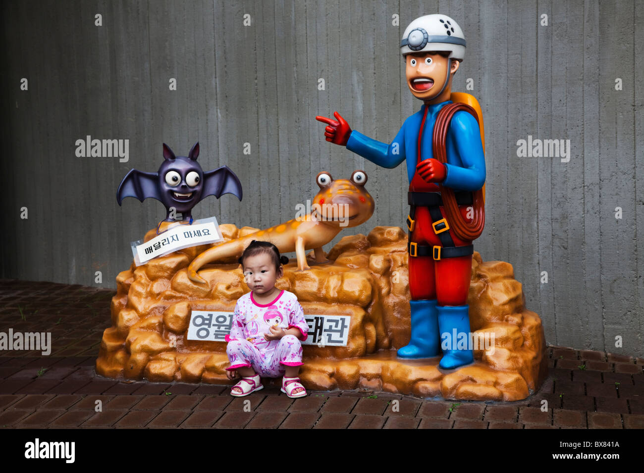 Korean girl est posant pour une photo prise par ses parents en face de l'entrée pour le parc à thème de Yeongwol, Corée du Sud Banque D'Images