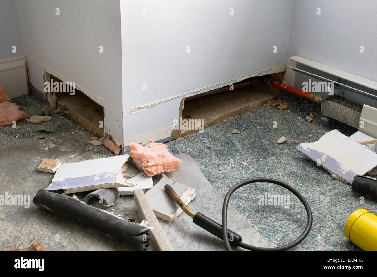 Plinthe retirée et cloisons sèches coupées à essayer de trouver  l'emplacement d'un tuyau de chauffage congelé Photo Stock - Alamy
