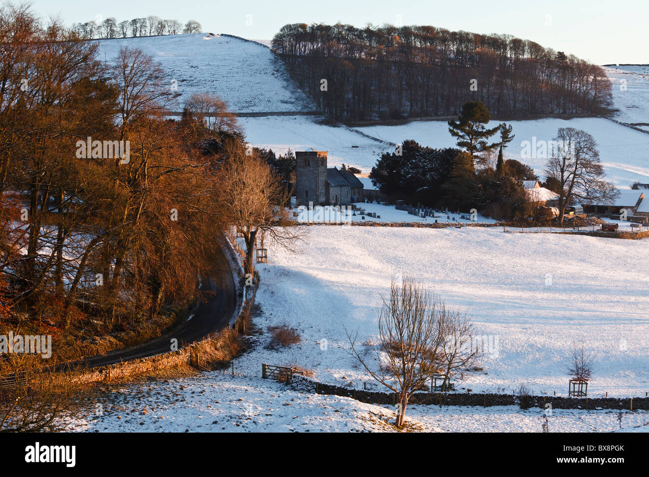 Le lever du soleil d'hiver baigne le minuscule village de Peak District Alsop en le Dale dans une lumière dorée, Derbyshire. Banque D'Images