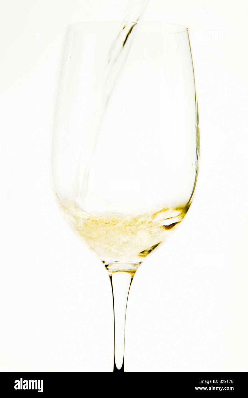 Verser le vin blanc dans un verre à dégustation Banque D'Images