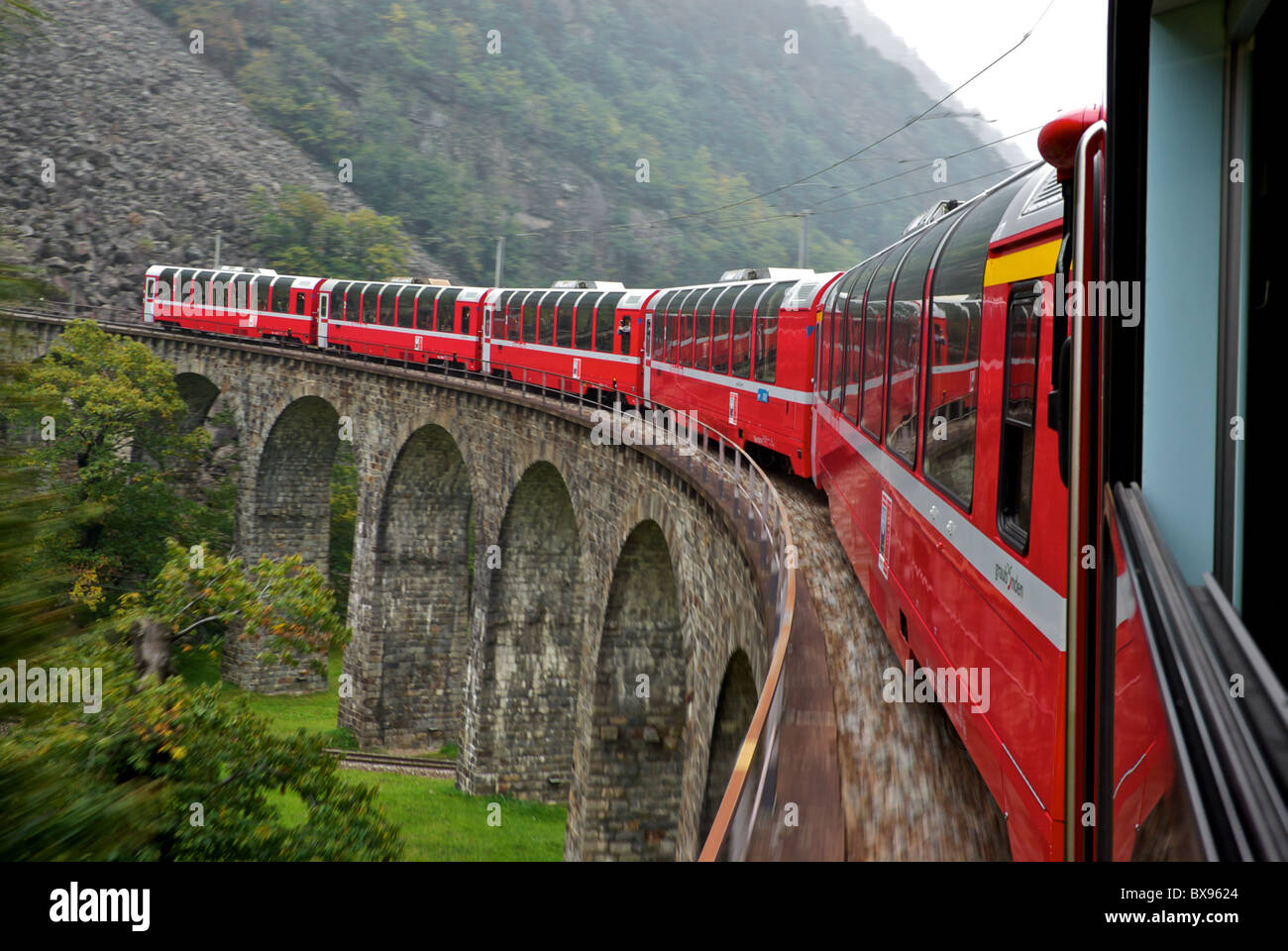 Paysage dans le motion blur UNESCO World Heritage chemin de fer rhétique train Bernina Express arrondit le viaduc de Brusio Italie circulaire Banque D'Images