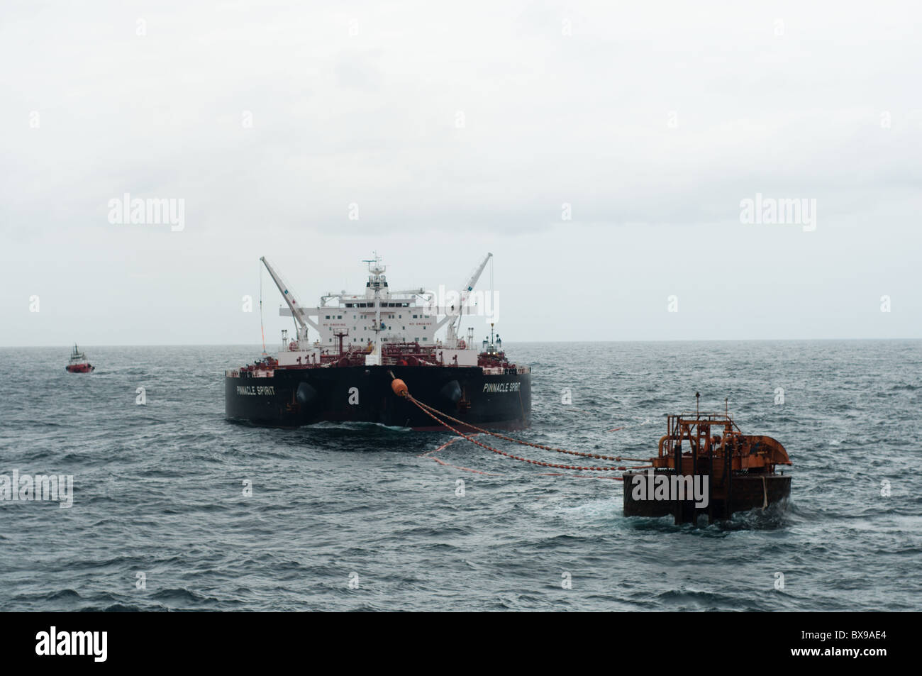 Oil Tanker navire ancré dans la zone au large des côtes en attente d'être chargés par une plate-forme pétrolière de production de Petrobras, la compagnie pétrolière brésilienne. Banque D'Images