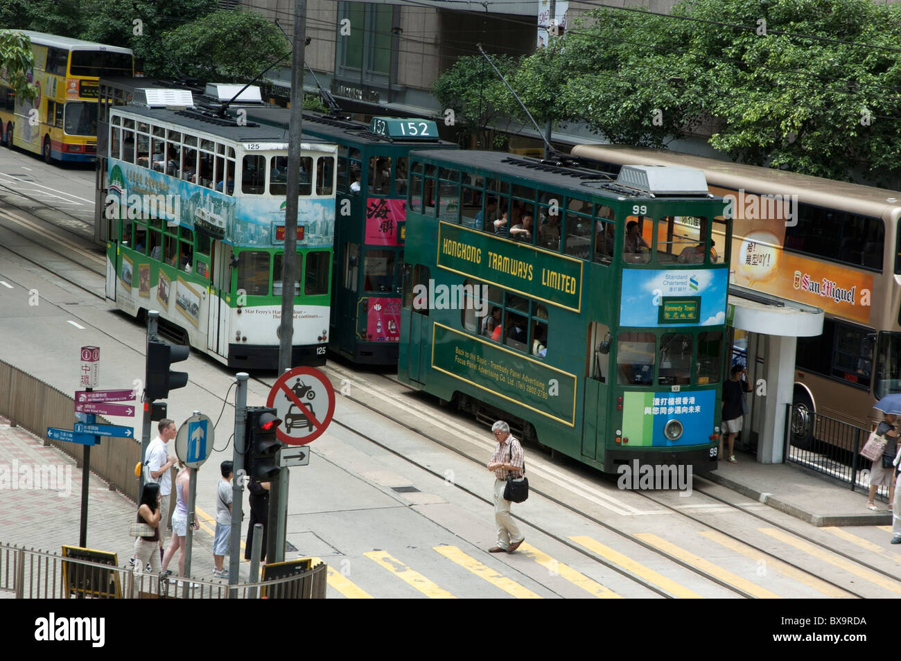 Double Decker trams passant dans la rue, l'île de Hong Kong, Hong Kong, Chine. Banque D'Images