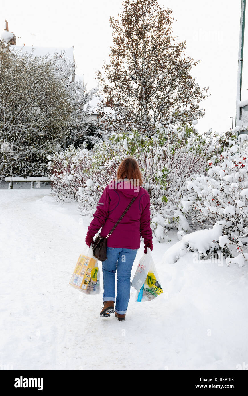 Shopping féminin dans des conditions hivernales england uk Banque D'Images