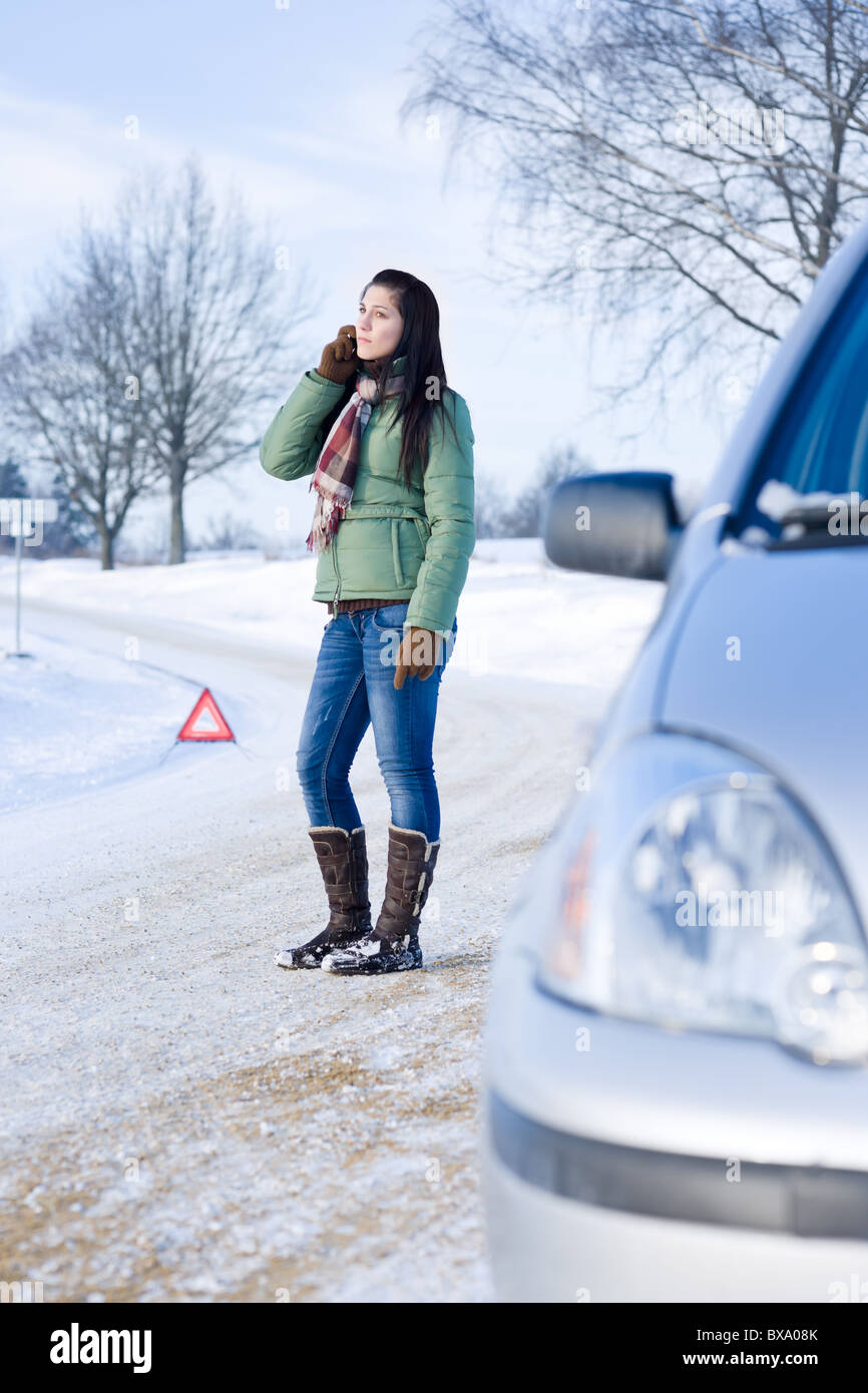 Panne de voiture d'hiver femme - appel à l'aide, assistance routière Banque D'Images