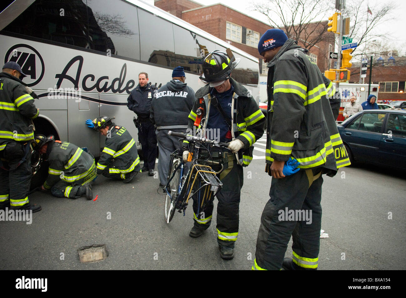 Les premiers intervenants déposer l'endommagement d'un cycliste après qu'il a été frappé par un autobus à New York Banque D'Images