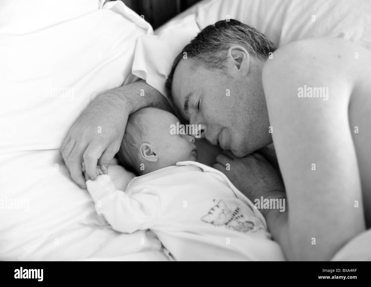 Heureux père de coucher avec new born baby holding hands Banque D'Images