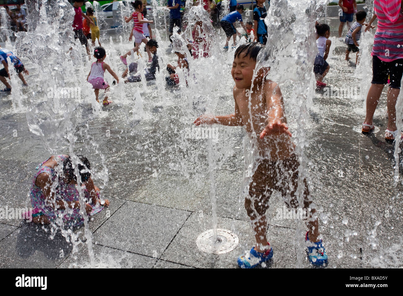 Les enfants jouent dans l'eau des fontaines dans Sejong à Séoul, Corée du Sud Banque D'Images