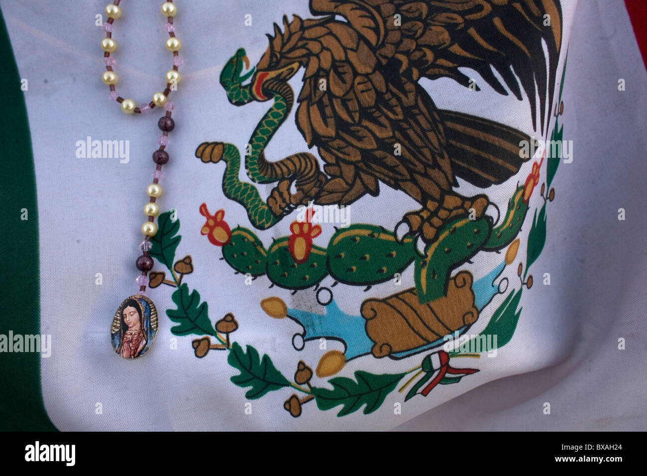 Un chapelet avec l'image de Notre Dame de Guadalupe décore un drapeau mexicain à Mexico Banque D'Images