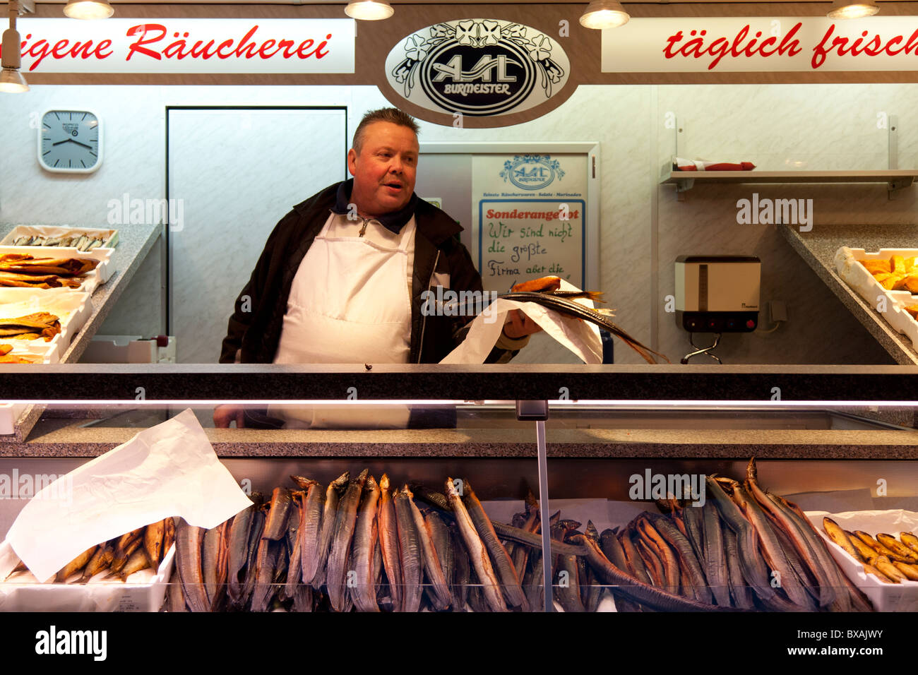 Un homme à l'anguille de vente du marché de poisson dans le quartier Sankt Pauli de Hambourg. Banque D'Images