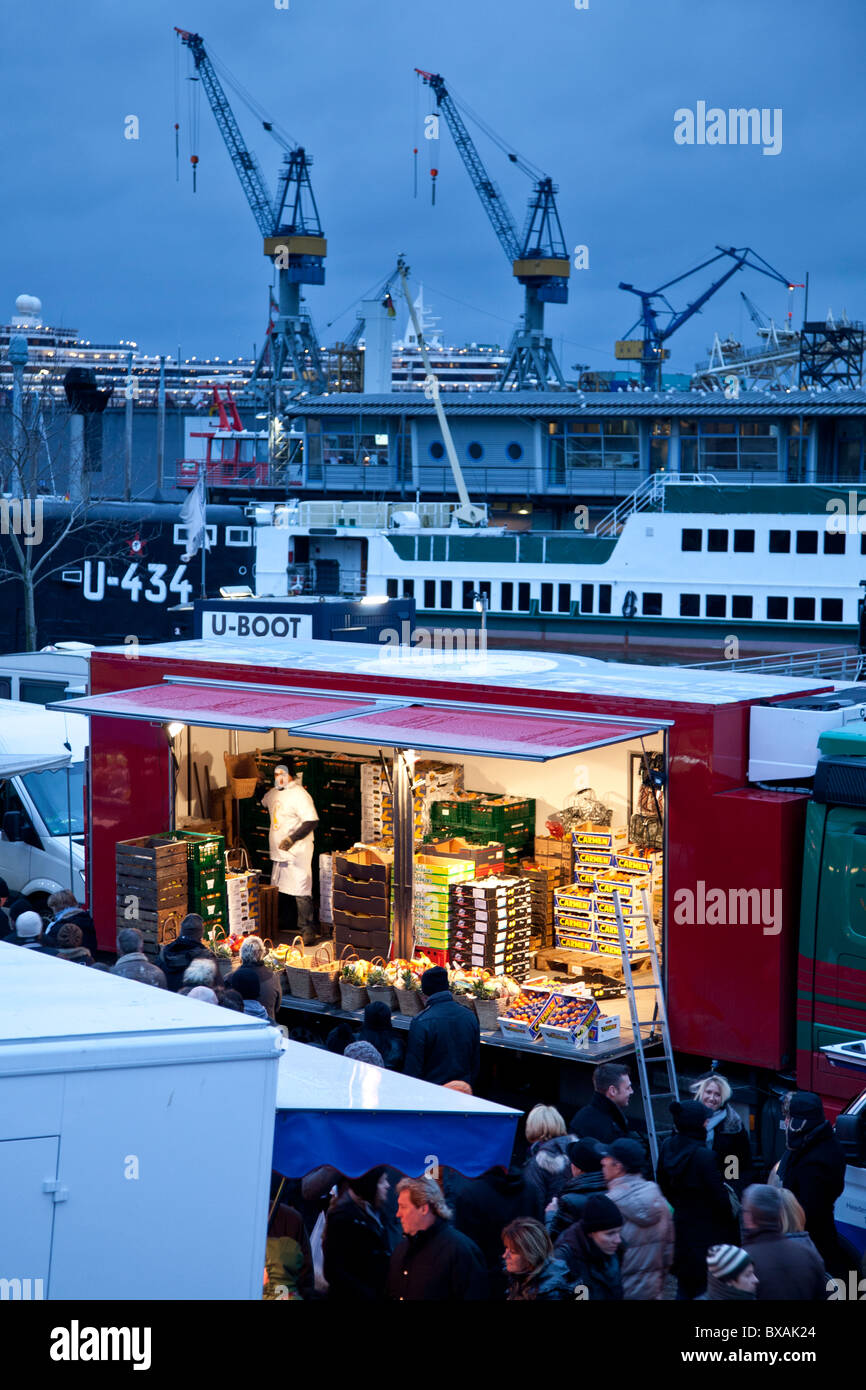 Un étal de fruits du marché aux poissons dans le quartier Sankt Pauli de Hambourg, le port bien visible dans l'arrière-plan. Banque D'Images