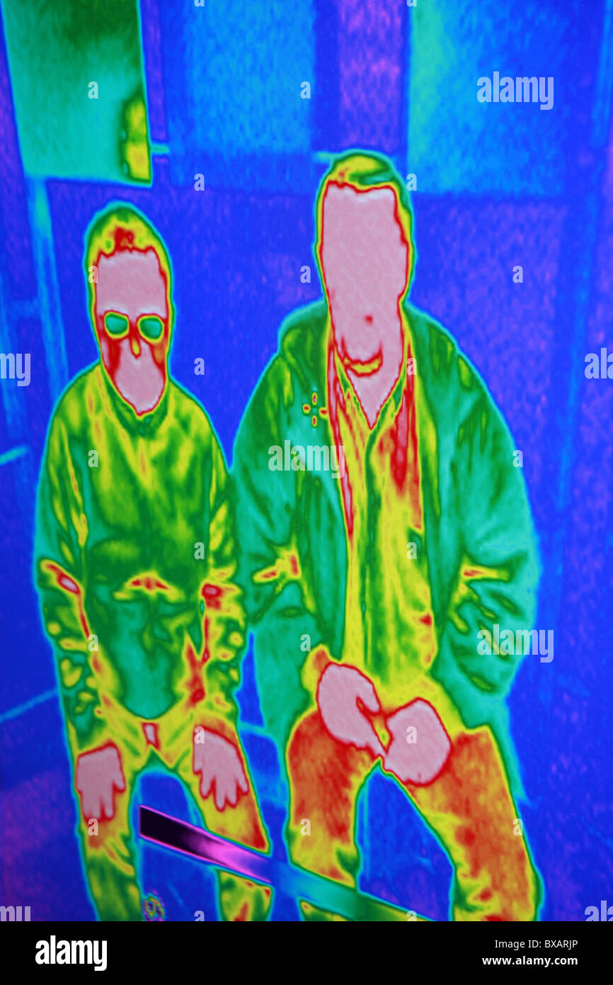 Une analyse thermique infrarouge de gens assis avec des couleurs de bleu, rouge, vert et jaune. Banque D'Images