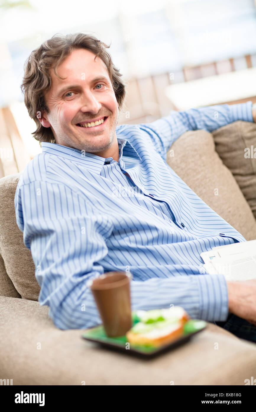 Portrait of mid-adult man sitting on sofa Banque D'Images