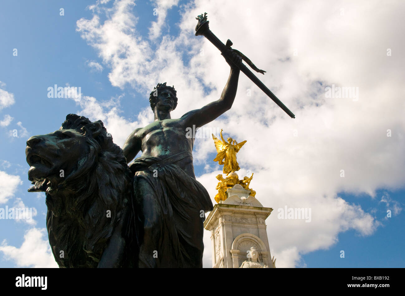 Victoria Memorial à l'extérieur de Buckingham Palace avec la statue de bronze représentant un homme assis sur un Lion des progrès Banque D'Images