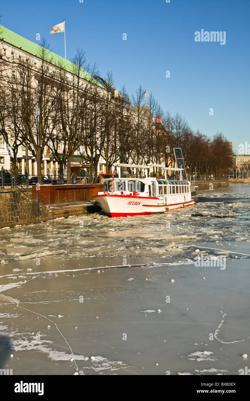 Vue sur les transports en bateaux pris dans la glace dans le lac Alster à Hambourg, Allemagne. Banque D'Images