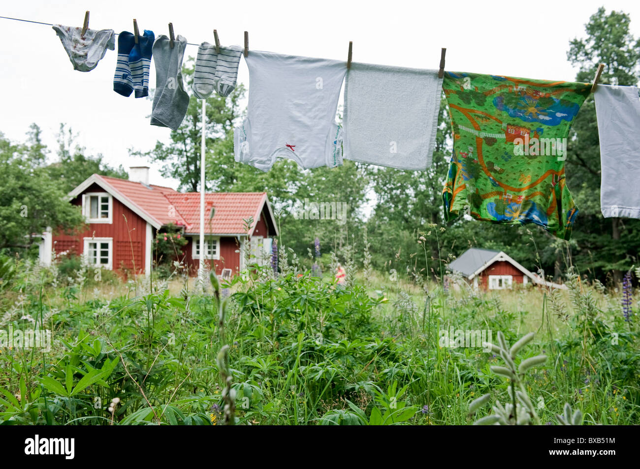 Vêtements accroché sur la ligne de lavage avec cottage en arrière-plan Banque D'Images