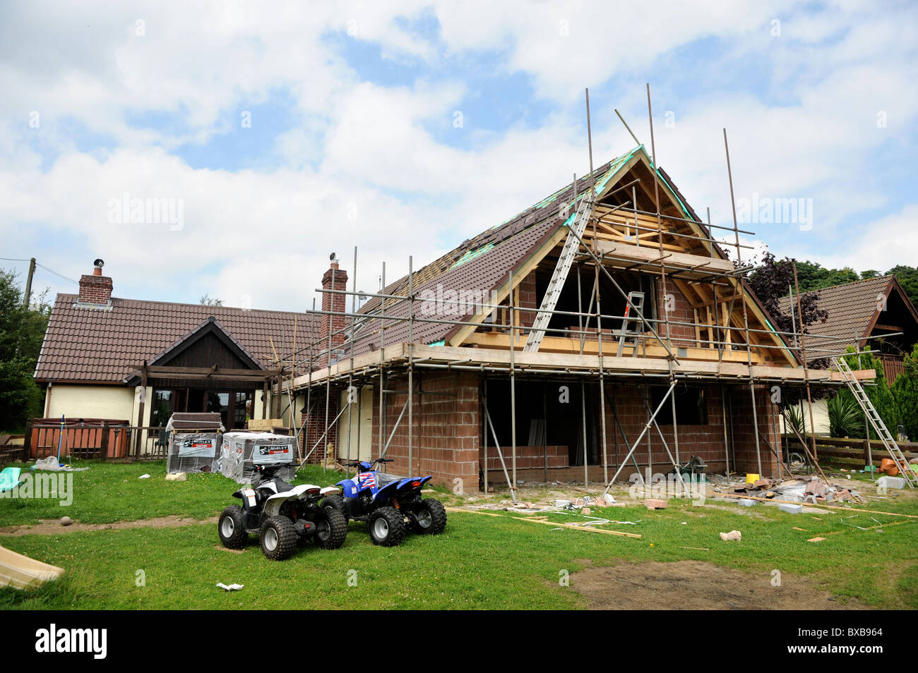 Une maison en cours d'extension avec deux quads dans le jardin du Pays de Galles, Royaume-Uni Banque D'Images Une maison en cours d'extension avec deux quads dans le jardin du Pays de Galles, Royaume-Uni Banque D'Images