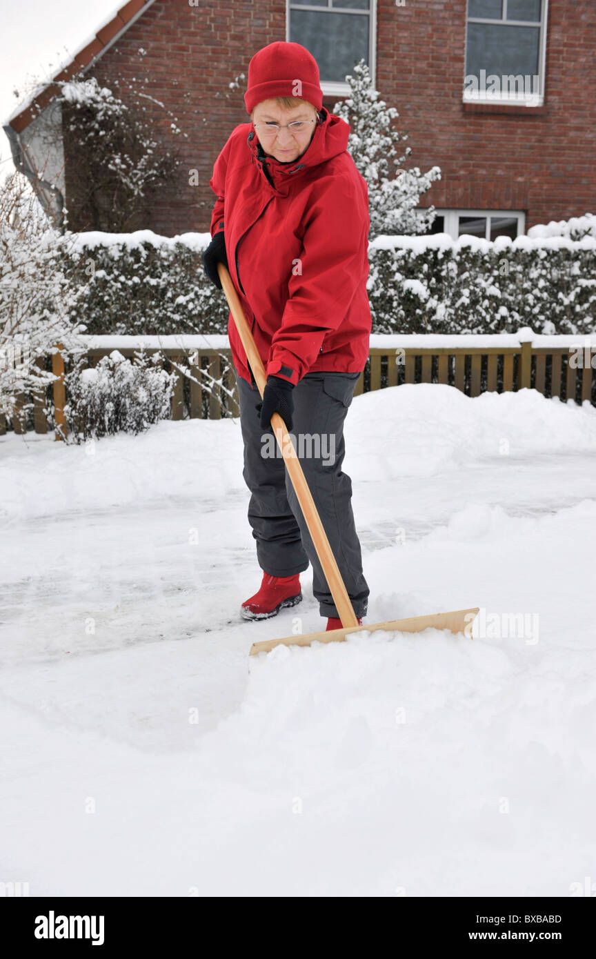 Femme déblayer la neige Banque D'Images