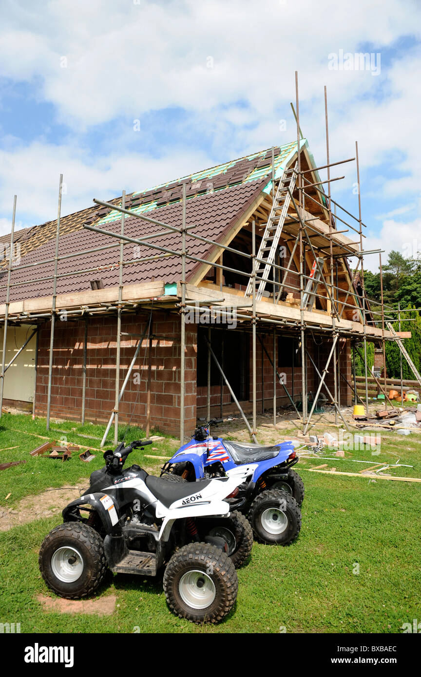 Une maison en cours d'extension avec deux quads dans le jardin du Pays de Galles, Royaume-Uni Banque D'Images Une maison en cours d'extension avec deux quads dans le jardin du Pays de Galles, Royaume-Uni Banque D'Images