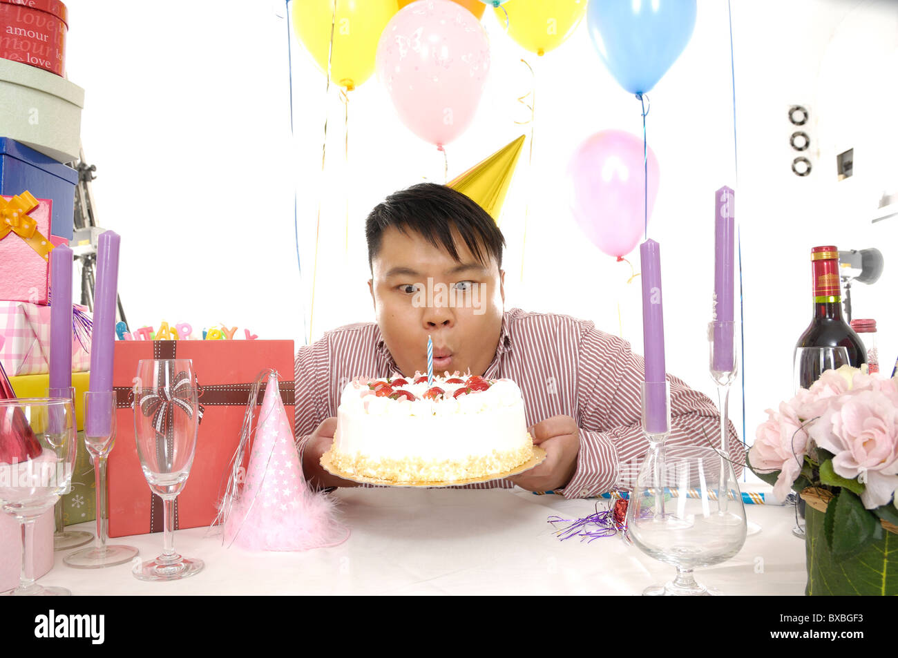 Man blowing out bougie sur un gâteau d'anniversaire Banque D'Images Man blowing out bougie sur un gâteau d'anniversaire Banque D'Images