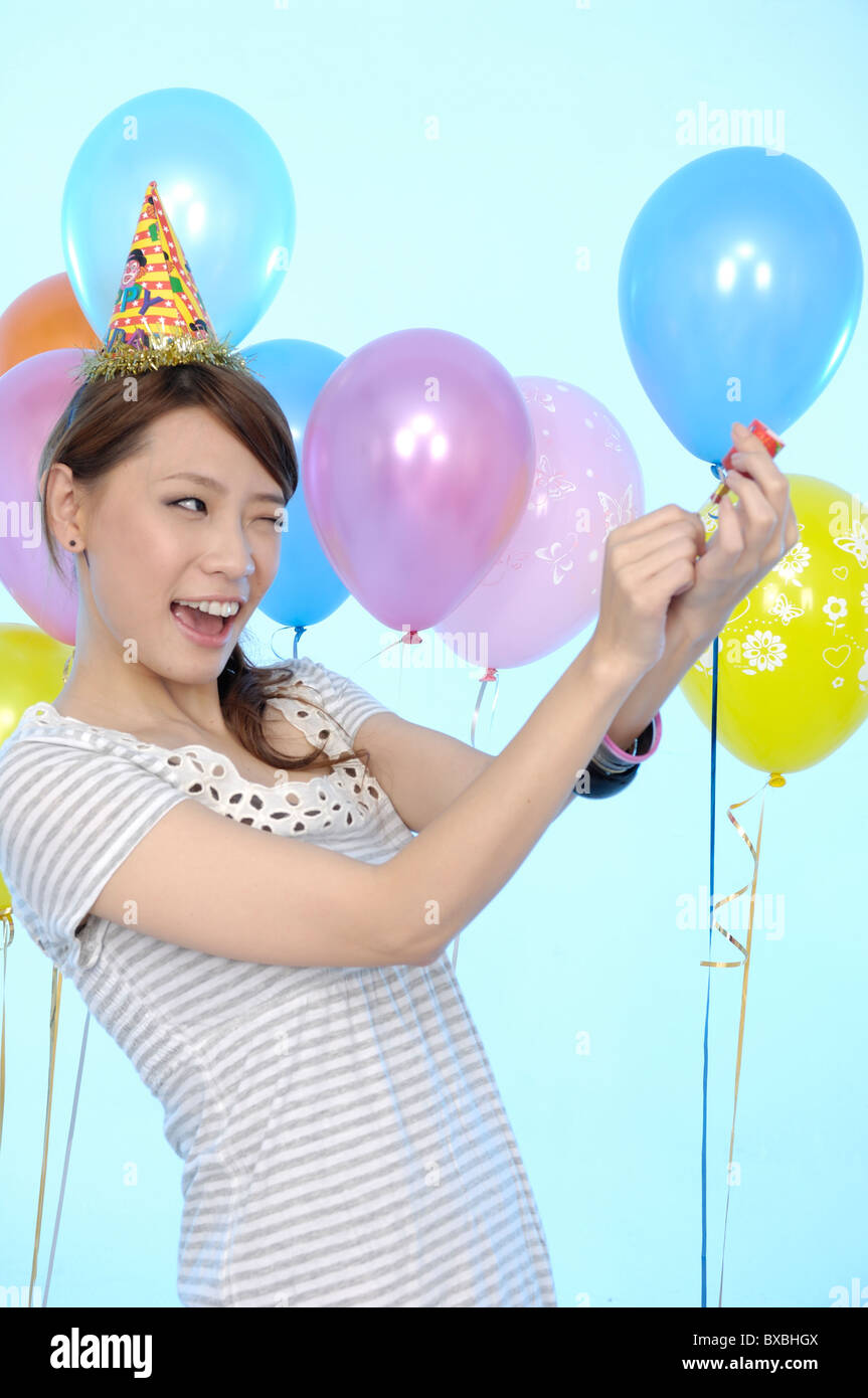 Femme de l'ouverture d'une partie dans un popper anniversaire Banque D'Images Femme de l'ouverture d'une partie dans un popper anniversaire Banque D'Images