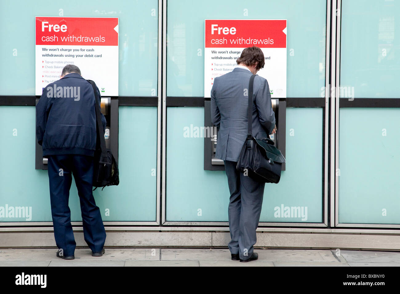 Les hommes à des distributeurs automatiques de la Banque HSBC à Londres, Angleterre, Royaume-Uni, Europe Banque D'Images