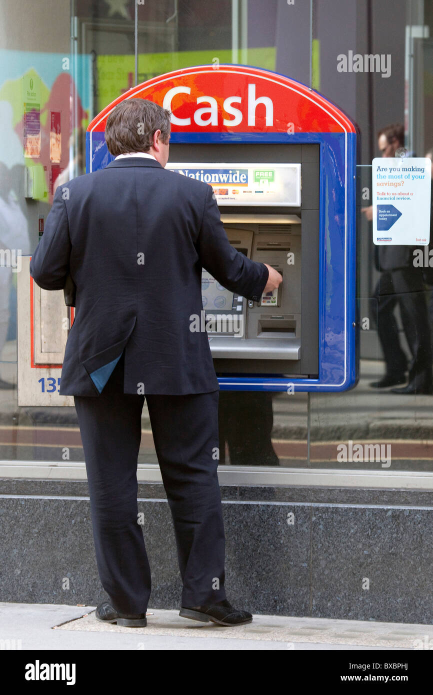 L'homme à un distributeur de billets de la Banque nationale à Londres, Angleterre, Royaume-Uni, Europe Banque D'Images