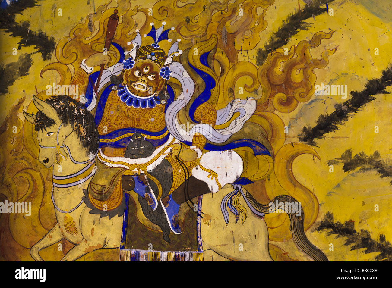 Peinture d'une déité bouddhiste mahakala sur un cheval avec des flammes jaunes autour de lui Banque D'Images