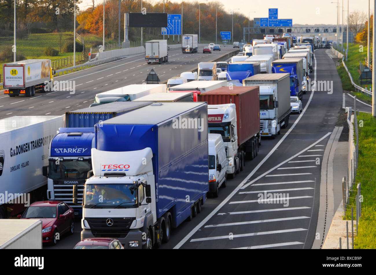 Autoroute M25 dans le sens horaire trois voies stationnaire bloqué en file d'attente poids lourds camions long embouteillage circulation libre circulation dans le sens anti-horaire Angleterre Royaume-Uni Banque D'Images