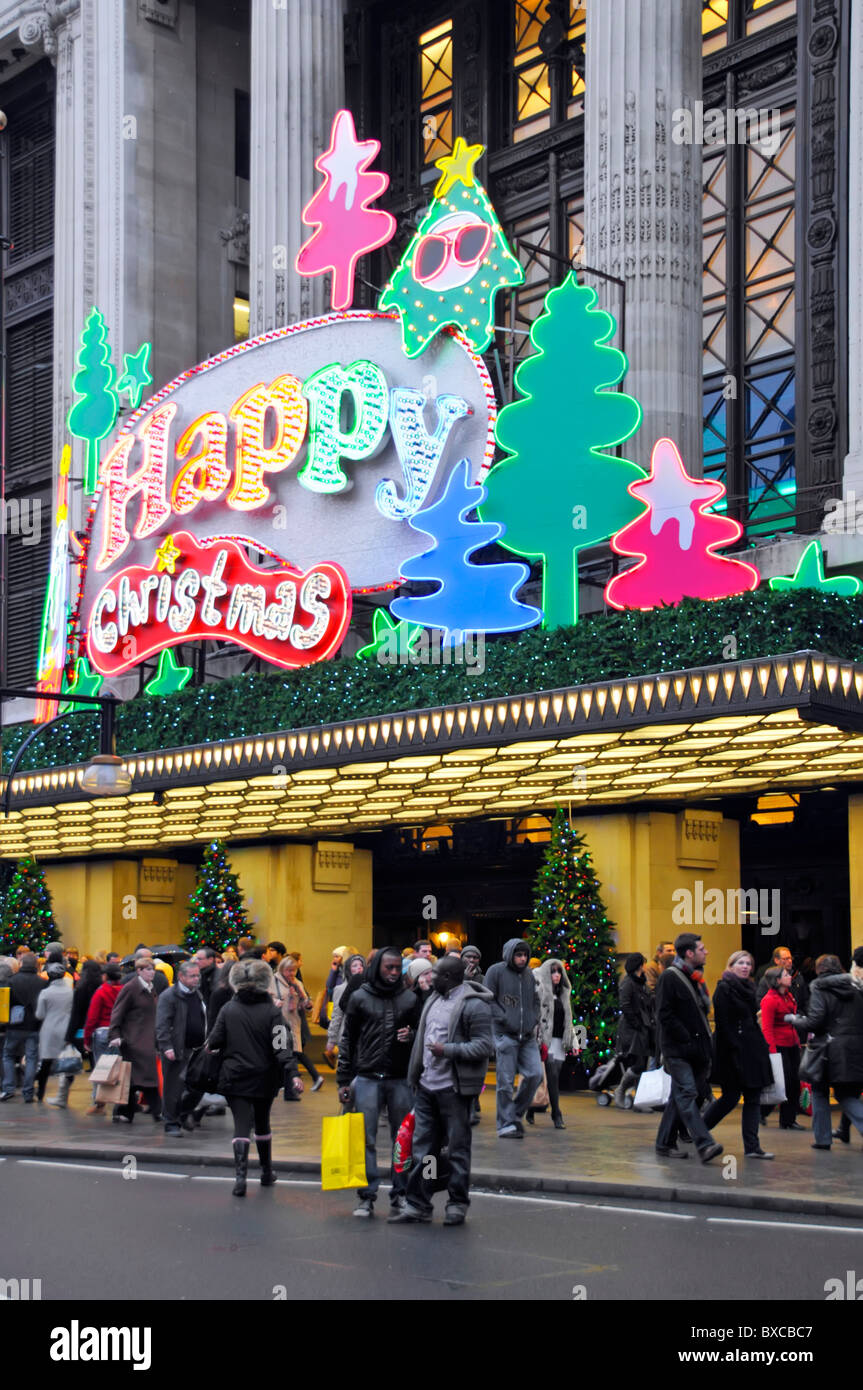 Shoppers & Joyeux Noël signe au-dessus de grand magasin Selfridges entrée principale dans Oxford Street West End de Londres Angleterre Royaume-uni Banque D'Images