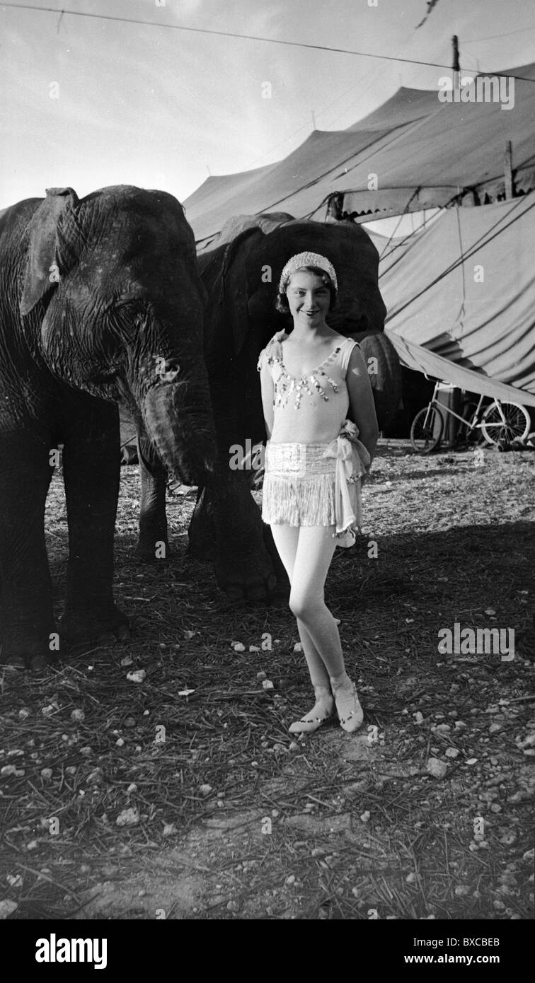 Artiste de cirque debout à côté d'éléphants à l'extérieur de la big top. femme femme fashion noir et blanc Années 1920 tenue de l'obturateur Banque D'Images