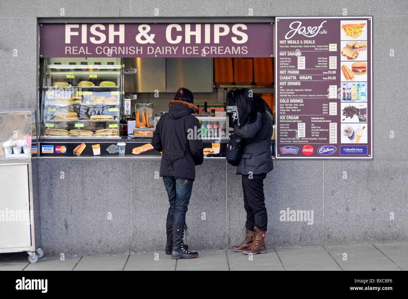 Fish and chips shop comptoir vue arrière deux touristes de clients magasiner pour la cuisine britannique traditionnelle par les personnes visitant la Tour de Londres Angleterre Royaume-Uni Banque D'Images