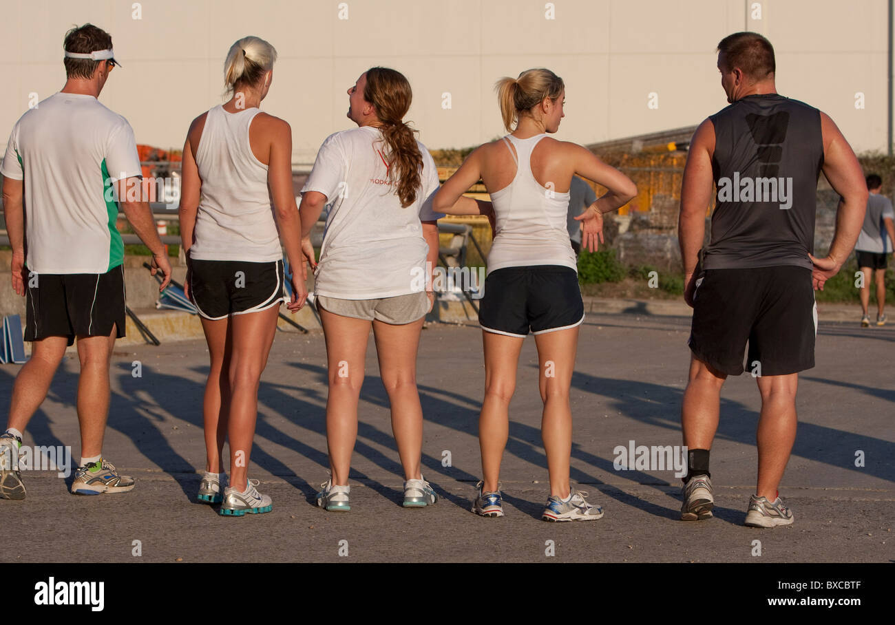 Les hommes et les femmes dans la classe d'exercice prendre une pause au cours d'une run dans le centre-ville d'Austin, Texas Banque D'Images