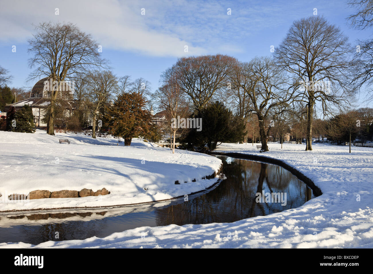 Buxton, Derbyshire, Angleterre, Royaume-Uni, Grande Bretagne. Rivière à travers le pavillon des jardins avec de la neige en hiver Banque D'Images