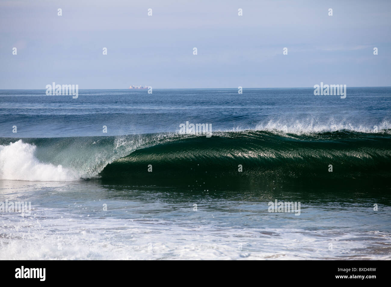 Une grande vague se brise avec force sur une barre de sable peu profond. Banque D'Images