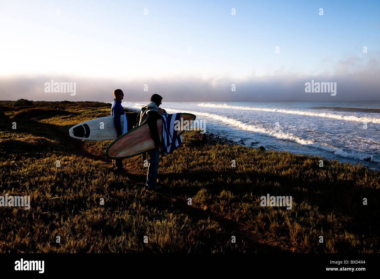 Deux jeunes surfeurs mâles randonnée pédestre le long d'un sentier. Banque D'Images