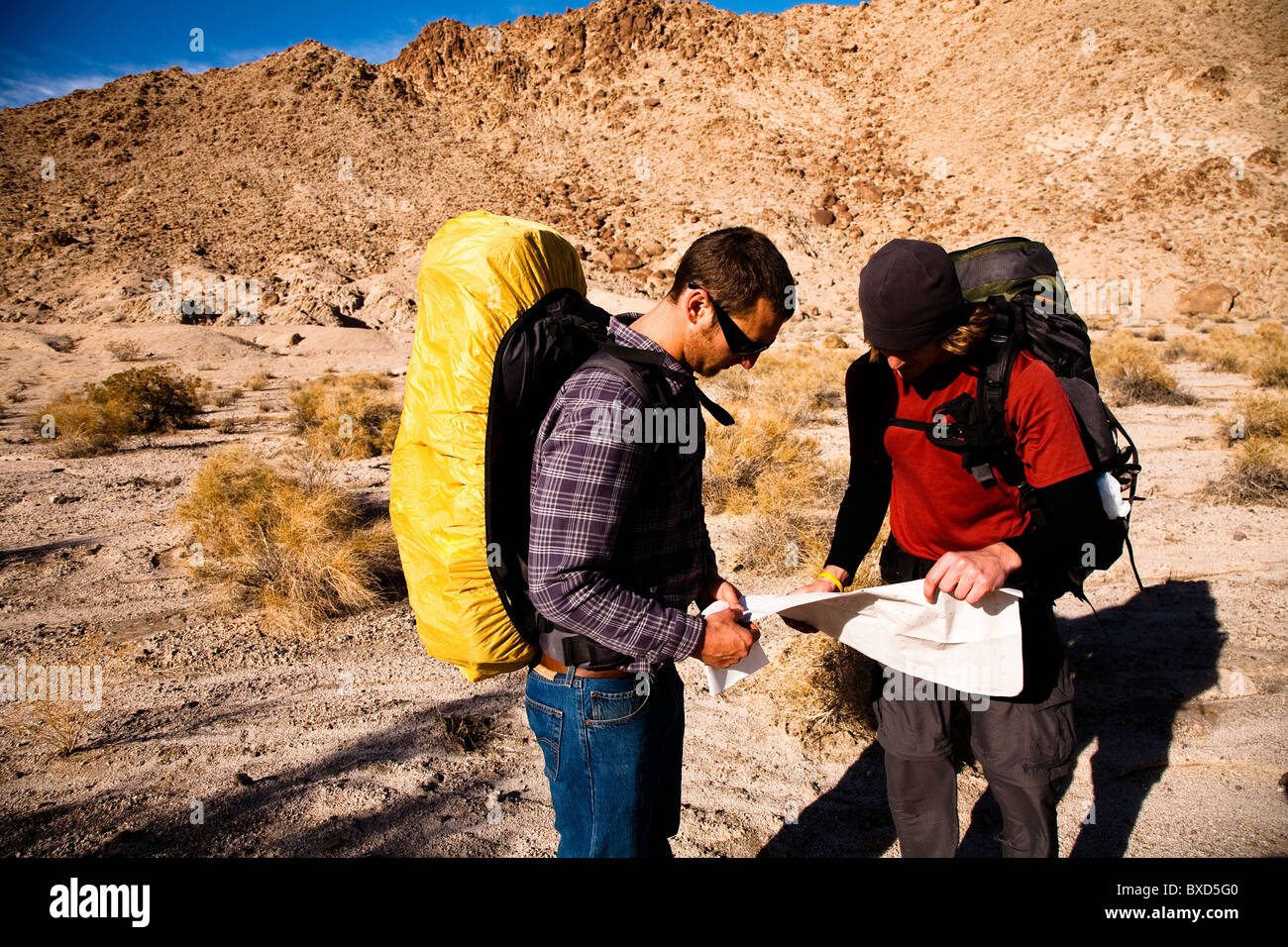 Deux hommes regarder les randonneurs sur une carte pendant la randonnée à travers les collines de la confiance dans la vallée de la mort Parc Nation, en Californie. Banque D'Images