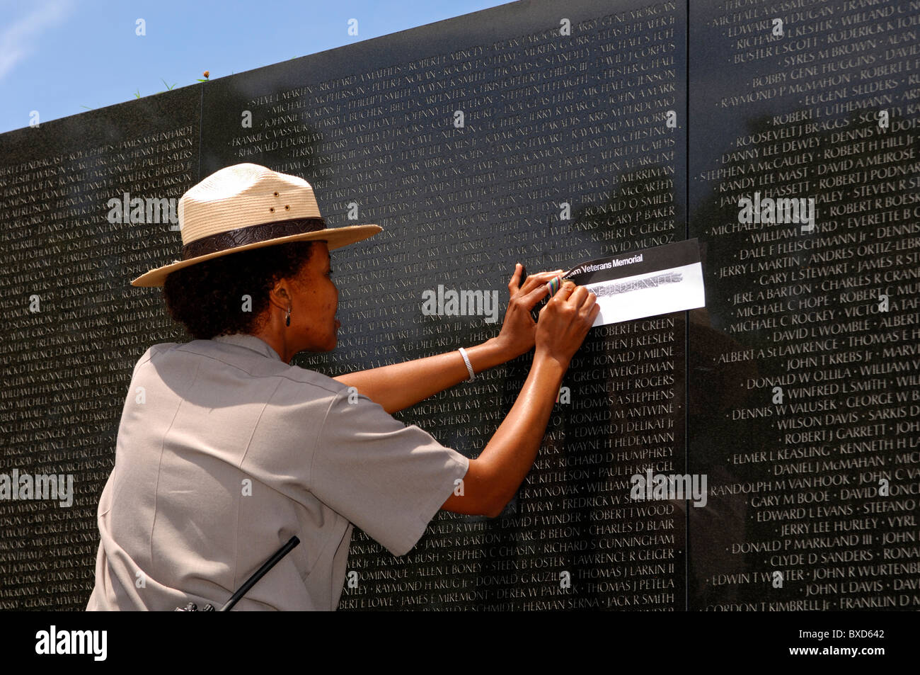 Park ranger copier le nom d'un militaire tombé d'un nom de tableau de bord, le Vietnam Veterans Memorial Wall, Washington, D.C., USA Banque D'Images