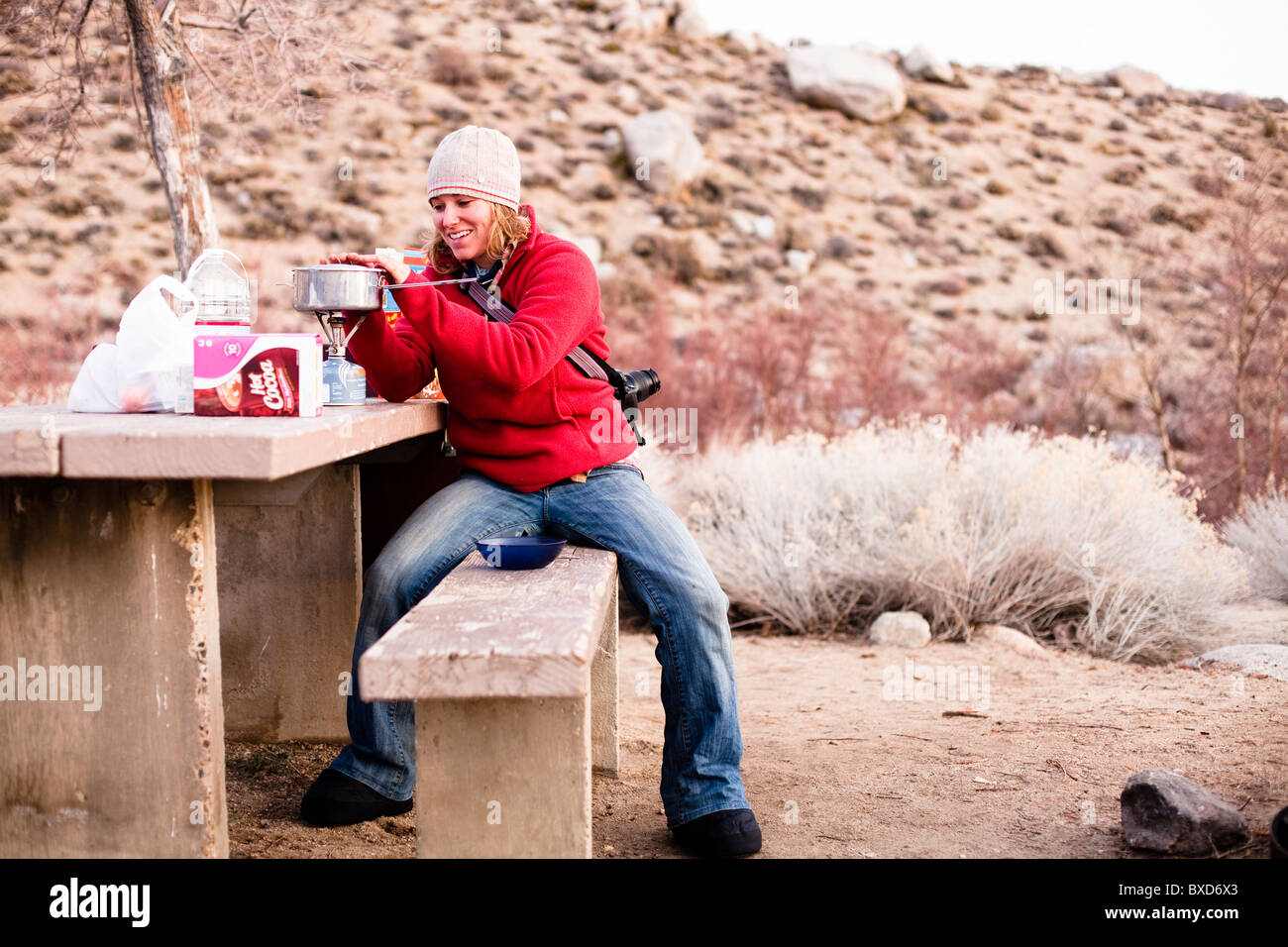 Une femme fait petit-déjeuner tout en camping dans la région de Lone Pine, en Californie. Banque D'Images